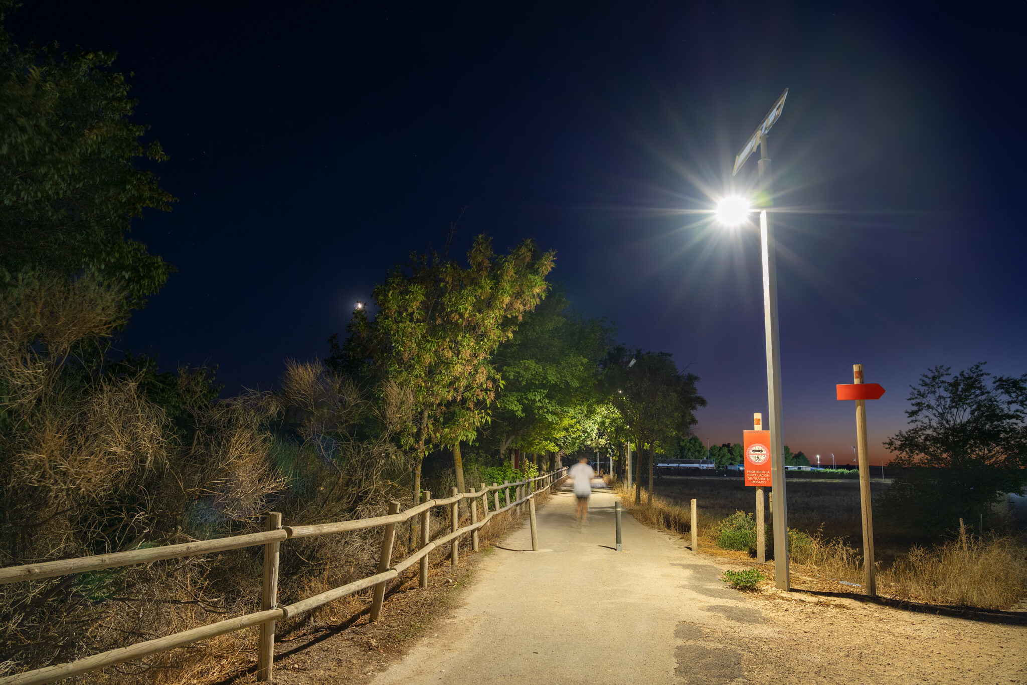 Solar streetlights in operation at dusk along a pedestrian or commercial path.